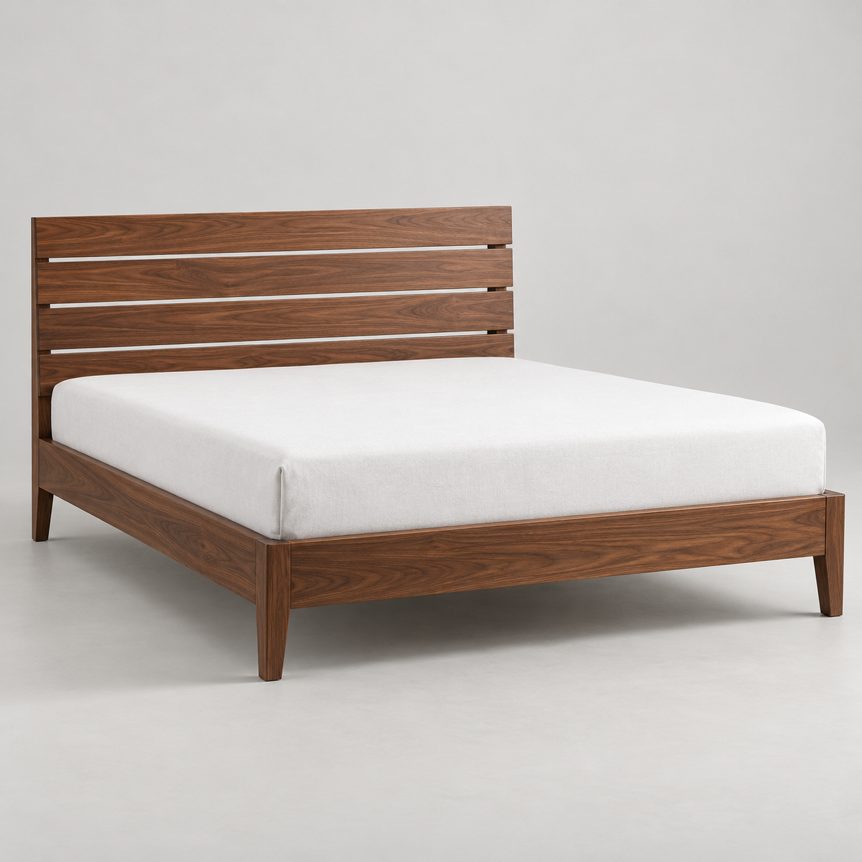Nido Walnut Bed on a pale studio background